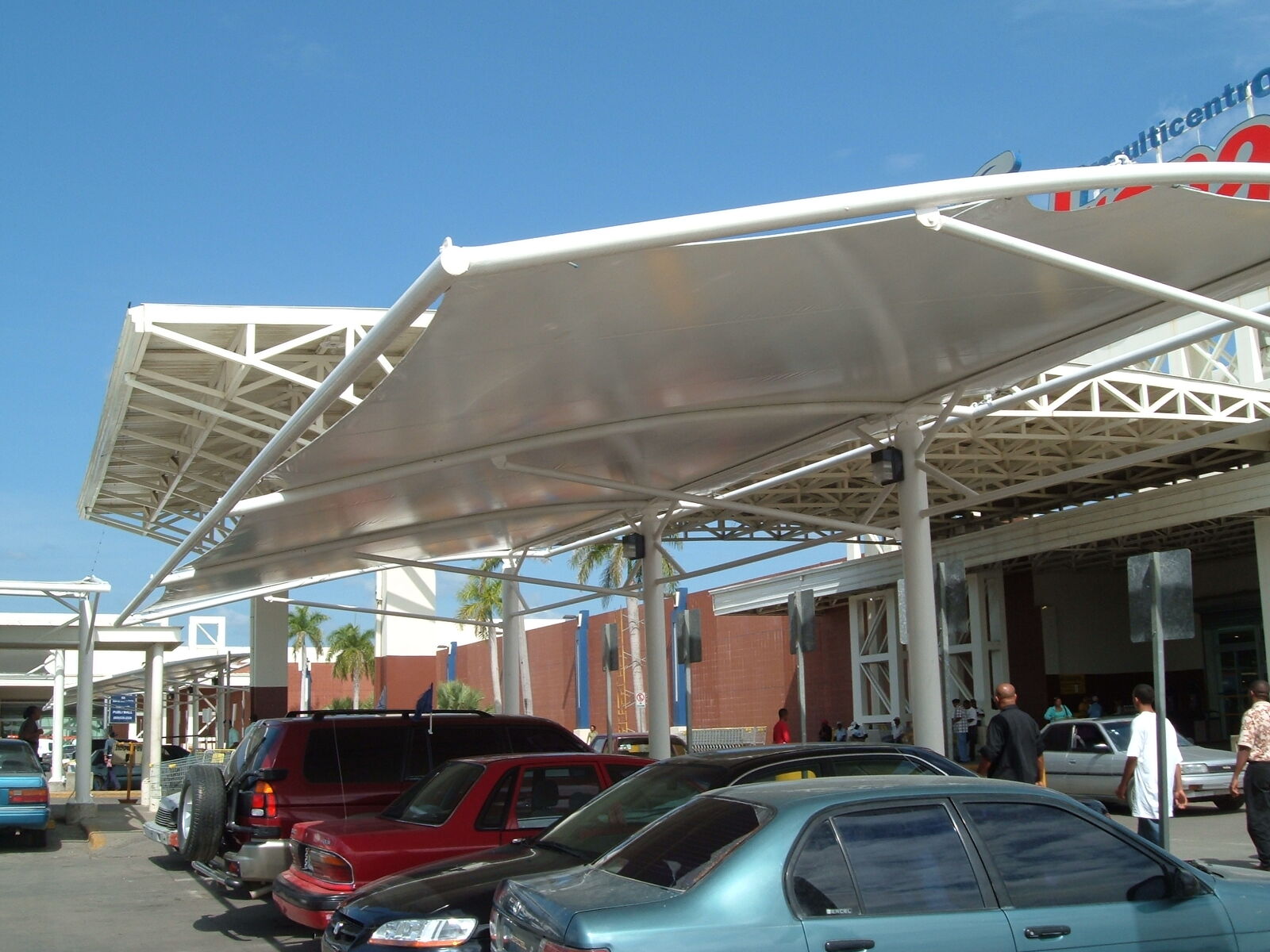 Cubierta tensada sobre parqueo frente a supermercado